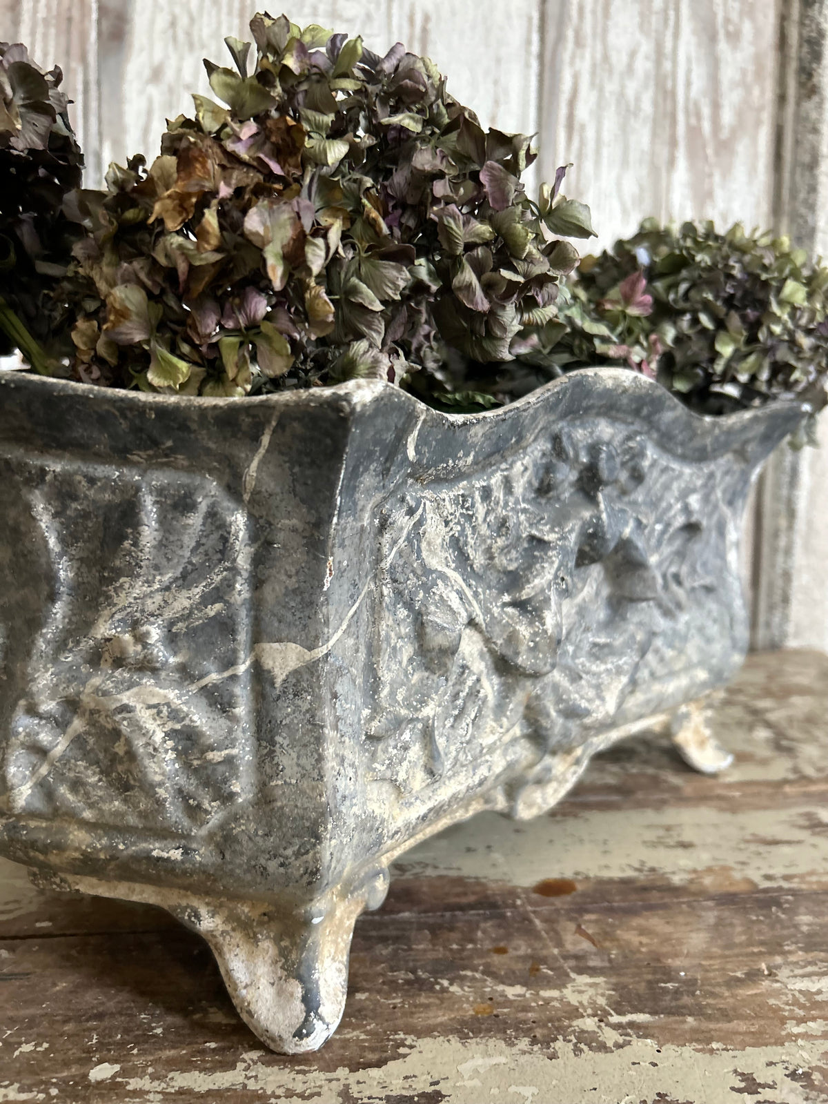 Antique french jardiniere with embossed floral/scroll relief and scroll feet.