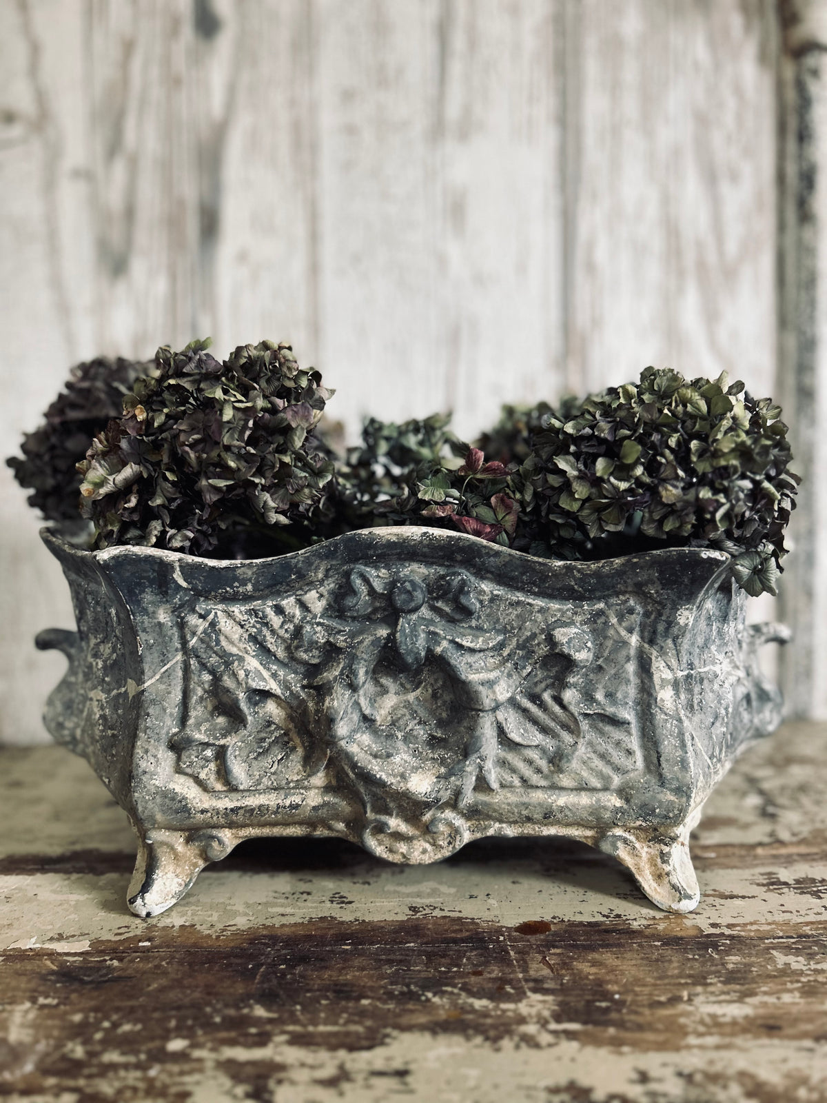 Antique french jardiniere with embossed floral/scroll relief and scroll feet.