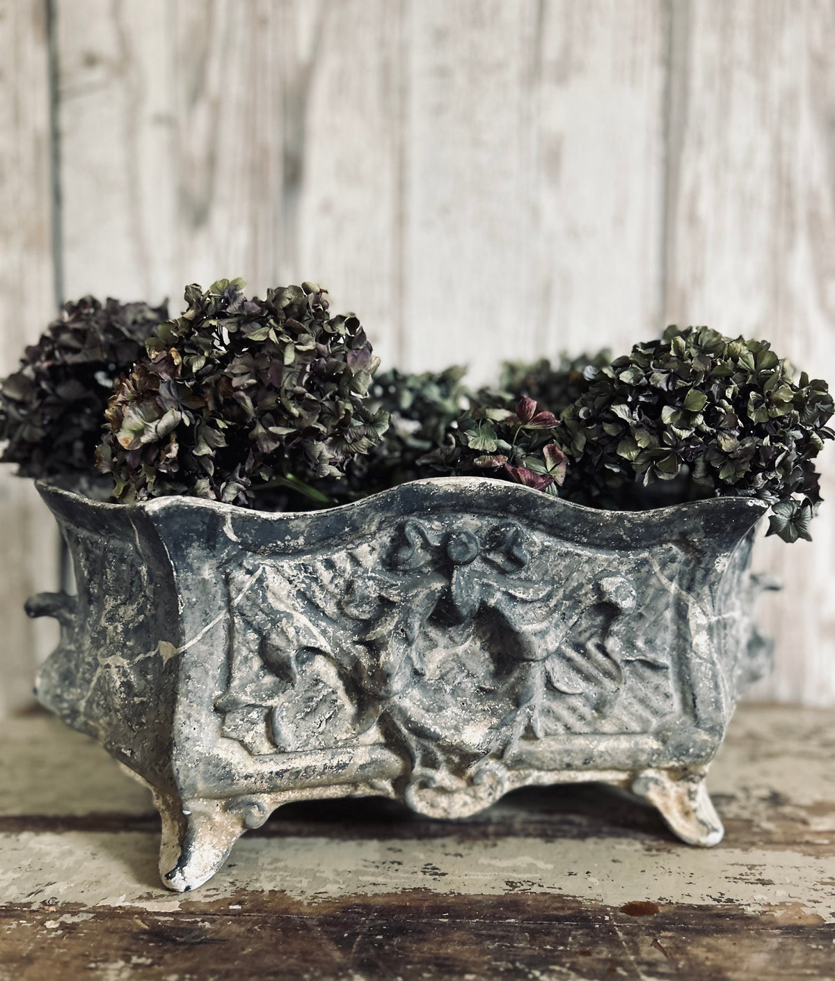 Antique french jardiniere with embossed floral/scroll relief and scroll feet.